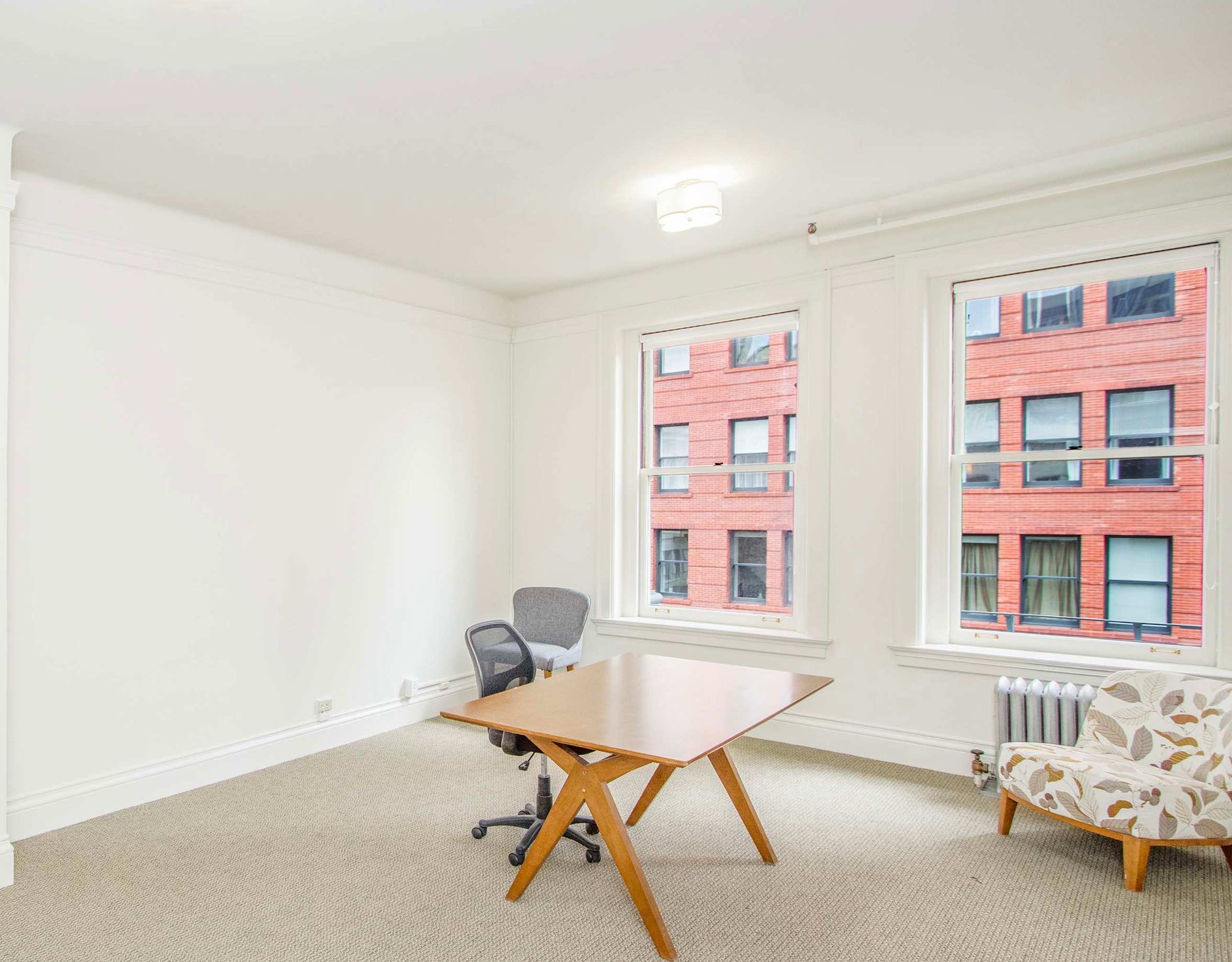 Private office with desk, windows, and natural light at 12 Geary Street
